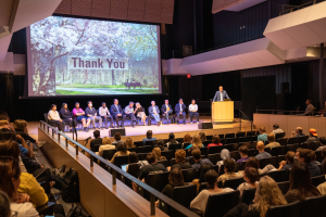Shows the Town Hall on Graduate Funding at L.R. Wilson Hall on June 7. The Task Force members are on stage and about 140 graduate students, faculty and staff are in attendance. 